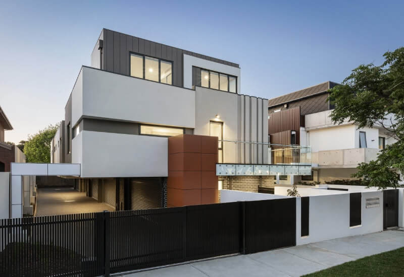 Contemporary two-story residence with contrasting textures and an open garage.